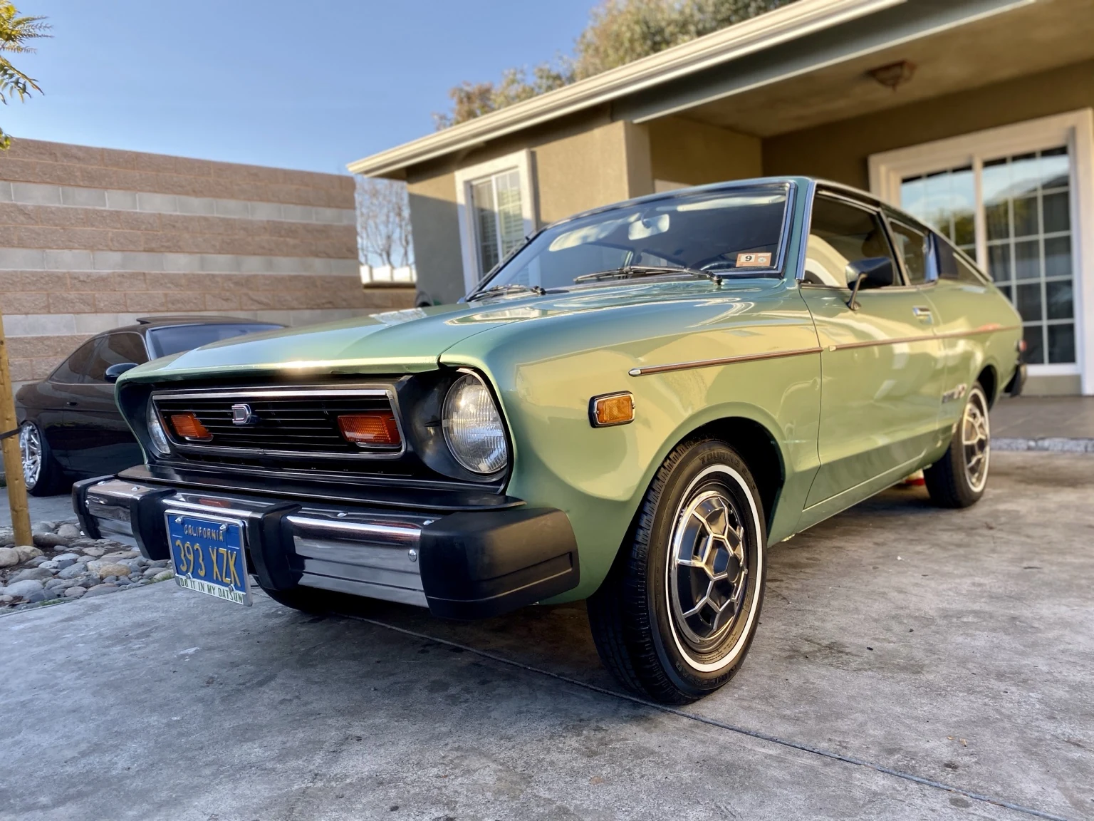 Classic green coupe in driveway